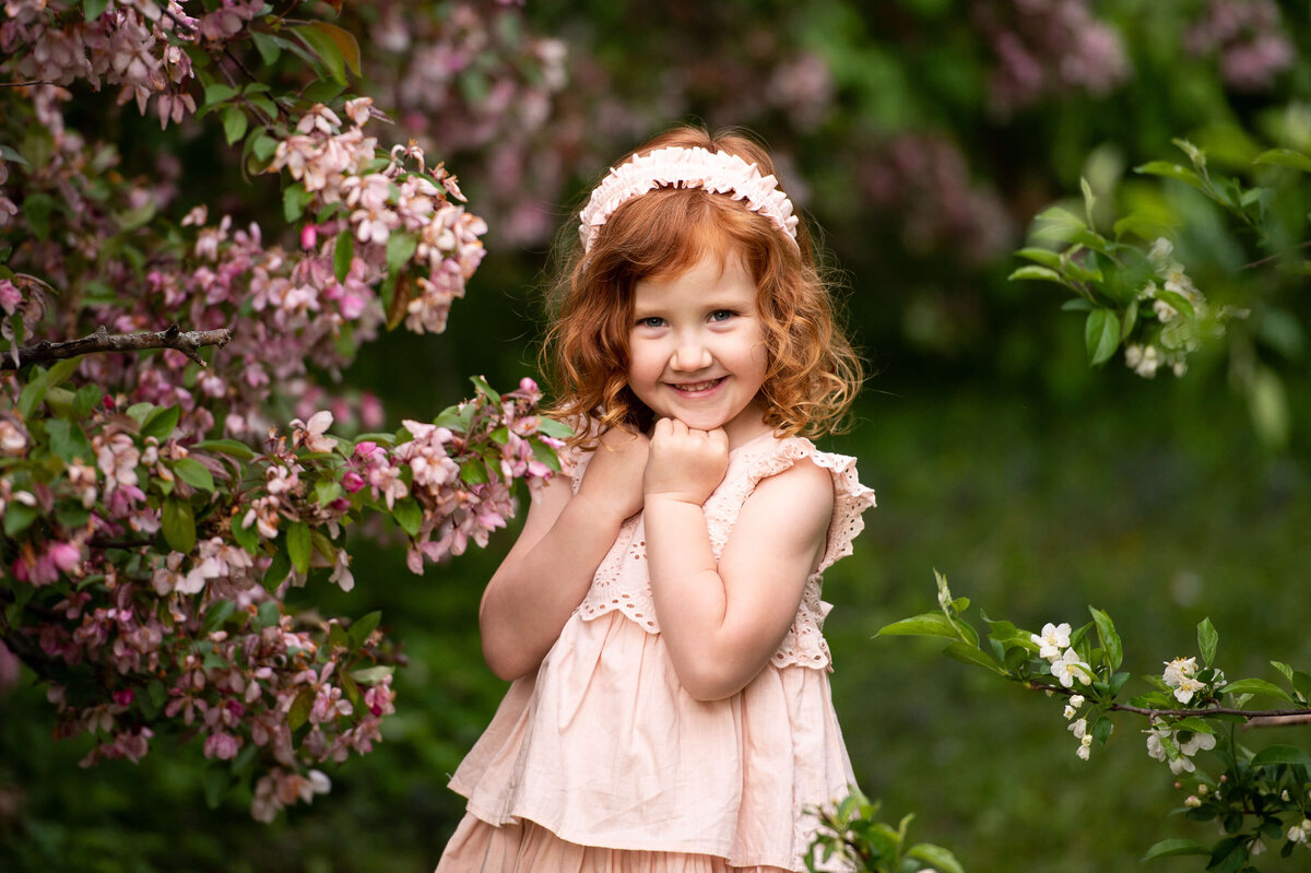 Ottawa family photography of a little girl with red hair and a pink dress surrounded by blossoms