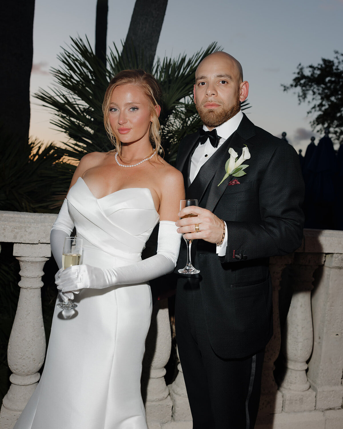 bride and groom hold champagne glasses