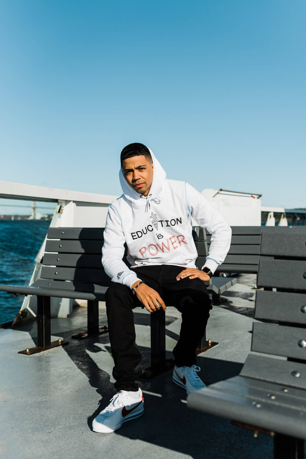 Man wearing a hoody while sitting on bench on Halifax ferry.