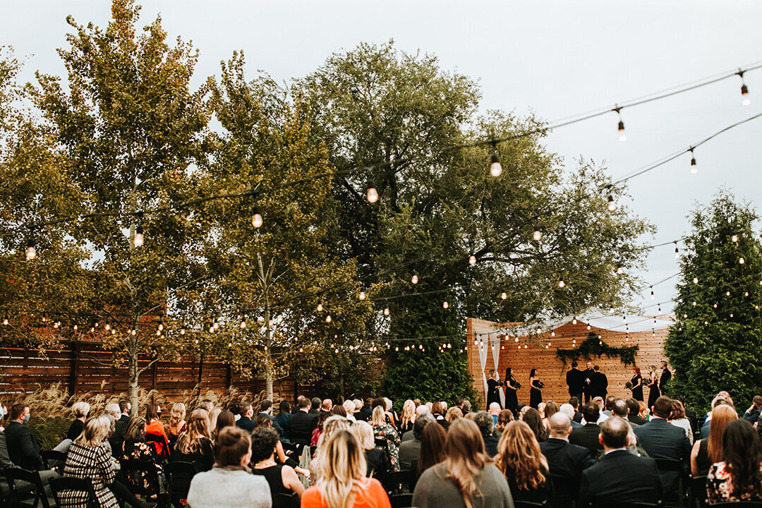 Wedding set outside with guests seated in chairs overlooking as the wedding takes place.