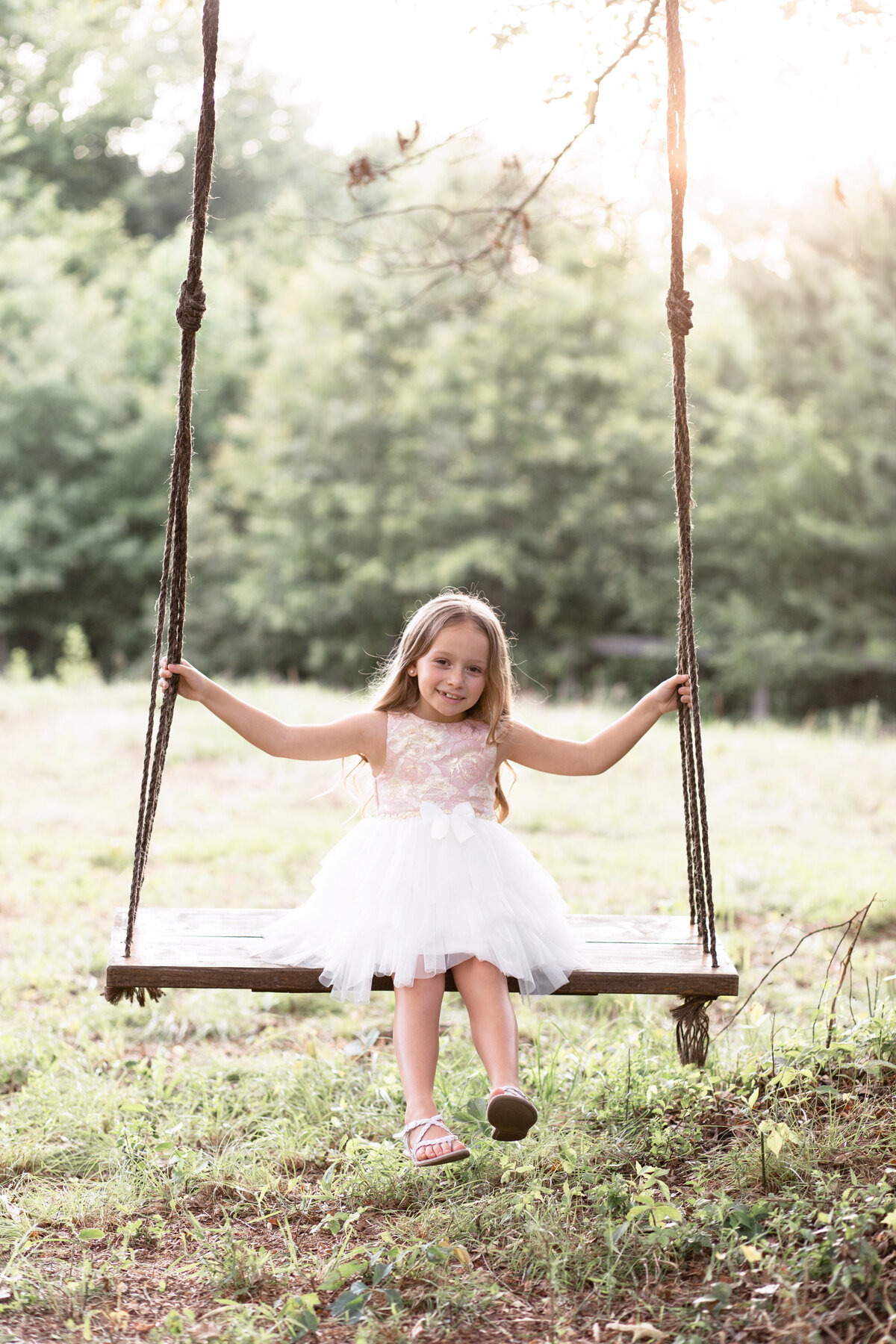 girl in white dress on a tree swing