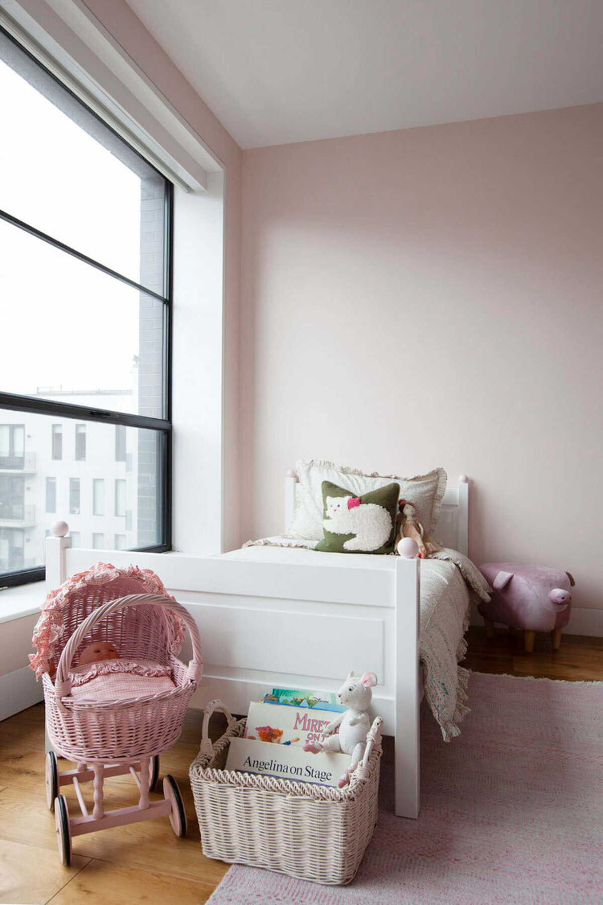 Stylish kids room with white bed and cat pillow, toy baby strollers