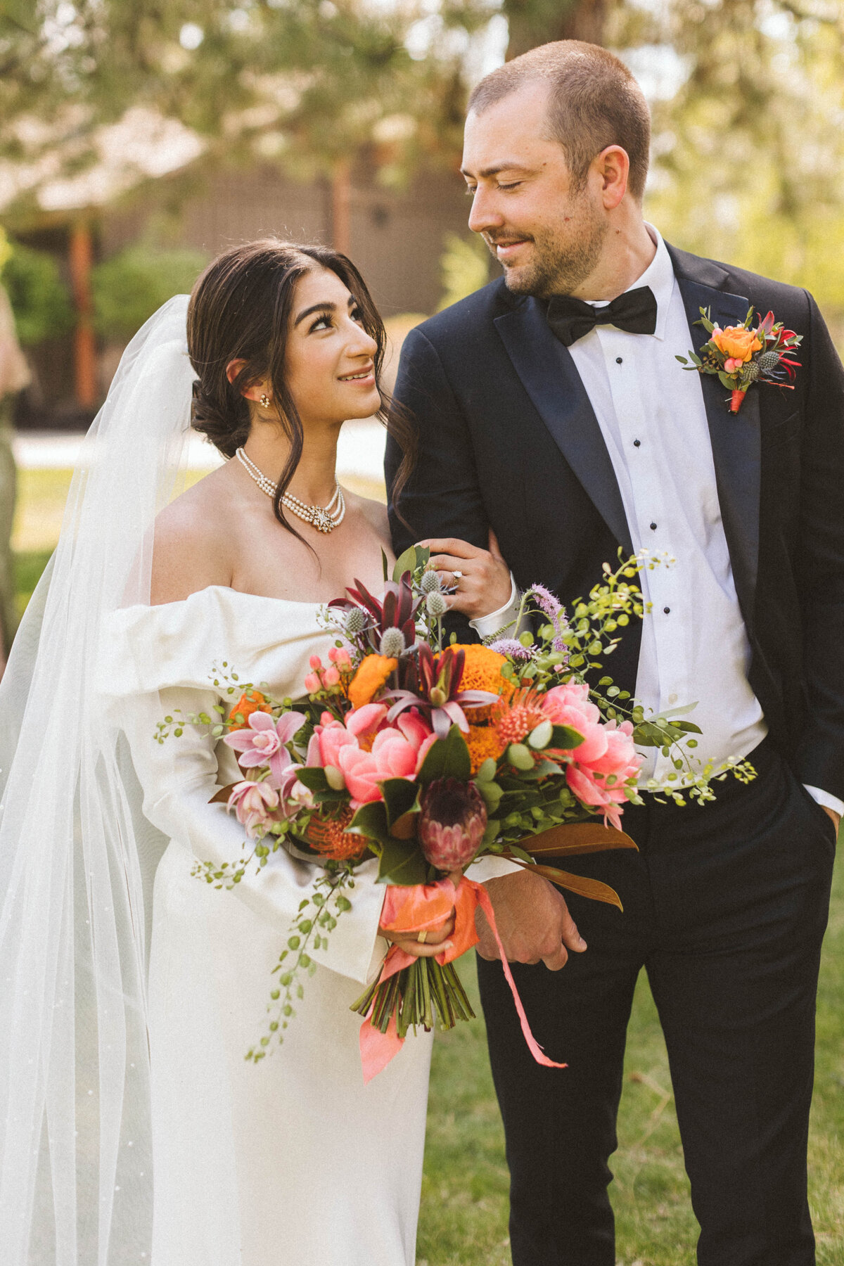 Bride and groom with bright Indian wedding bouquet with marigolds at Sunriver Resort