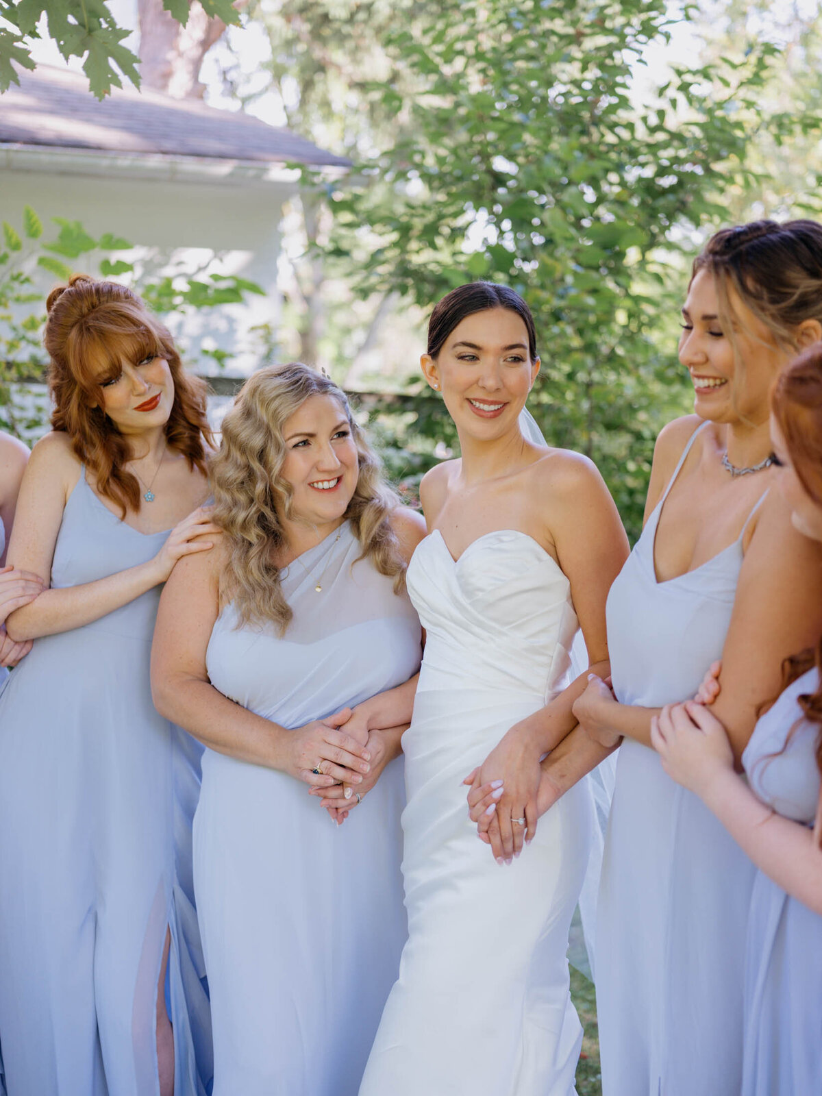 Bride in Maggie Sottero gown with bridesmaids in blue Birdy Grey dresses.