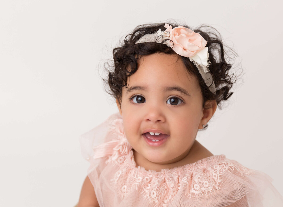 6-month-old baby girl wearing a floral crown during her NYC baby milestone photoshoot. Professional baby photography capturing the best moments in New York City