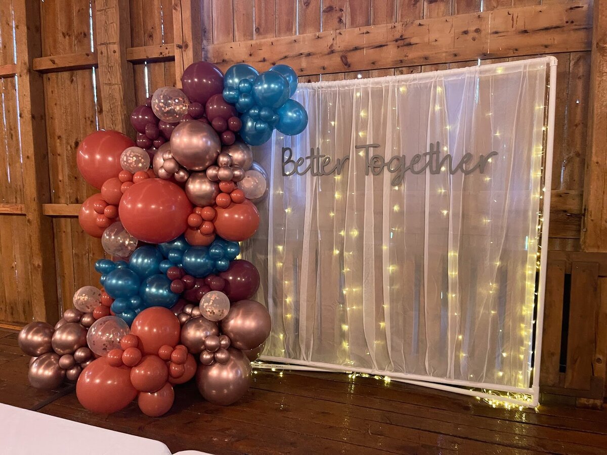 White wedding photobooth with better together sign and colorful balloons