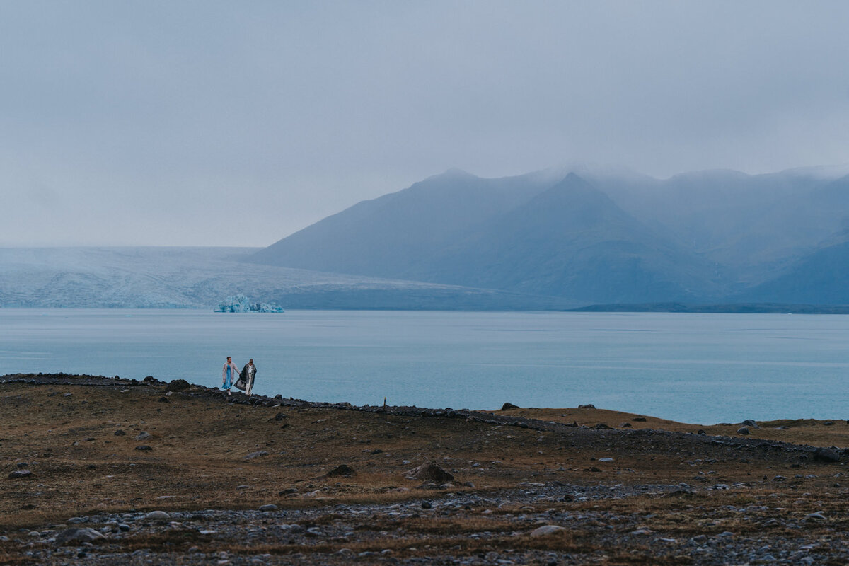 Women stand near a glacial lagoon in Iceland 