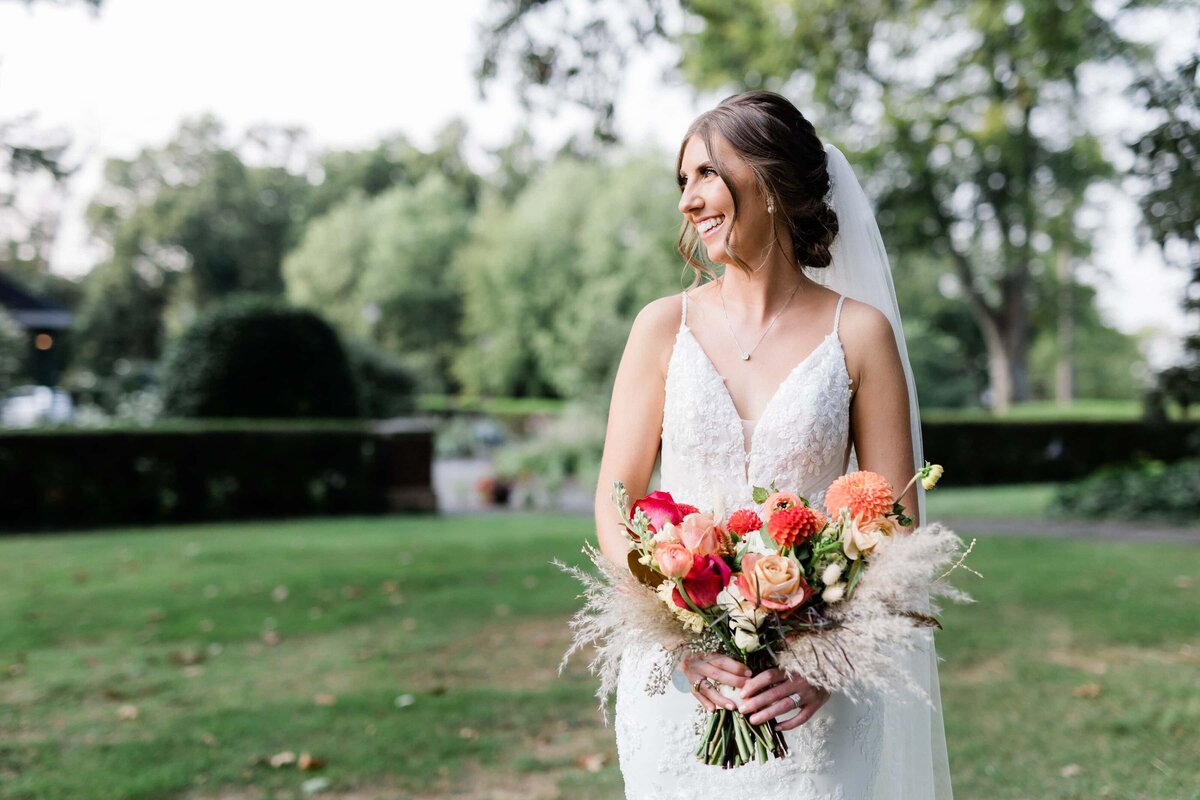 Bride smiling holding her colorful bouquet at Box Hill Mansion