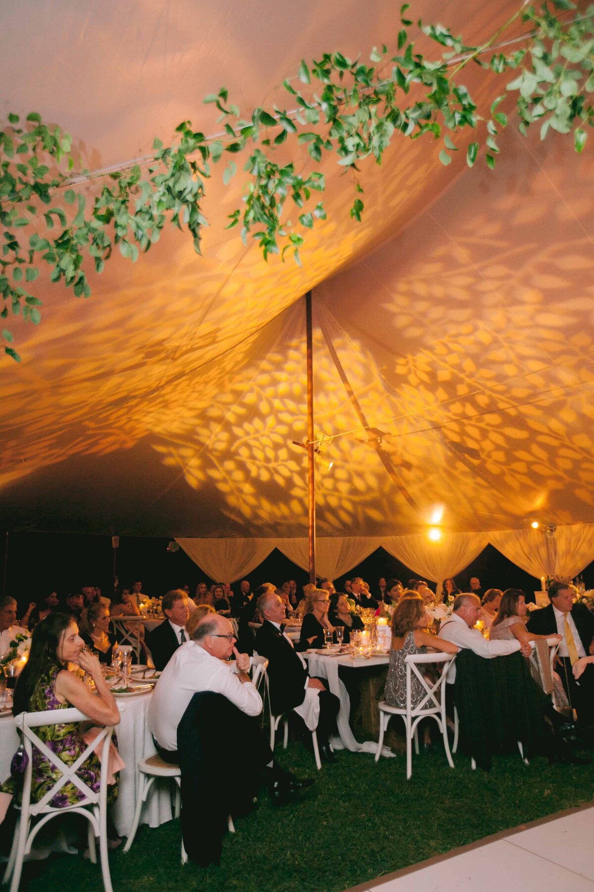 Wedding guests enjoying toasts under a custom garland
