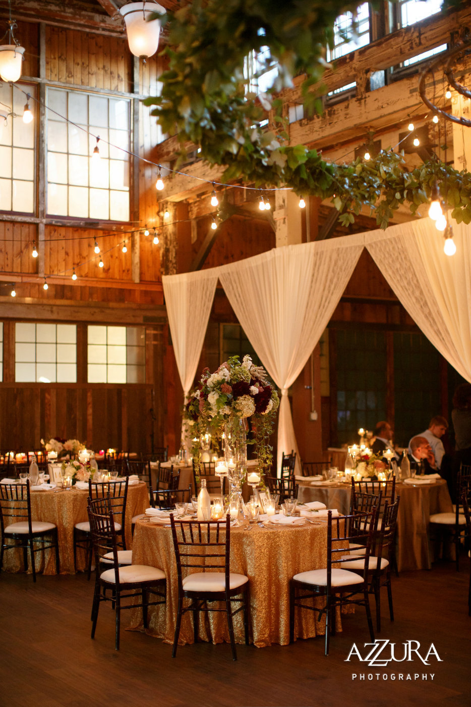 wedding reception at Sodo Park Seattlewith sequin linens and brown Chivari chairs and wall draping