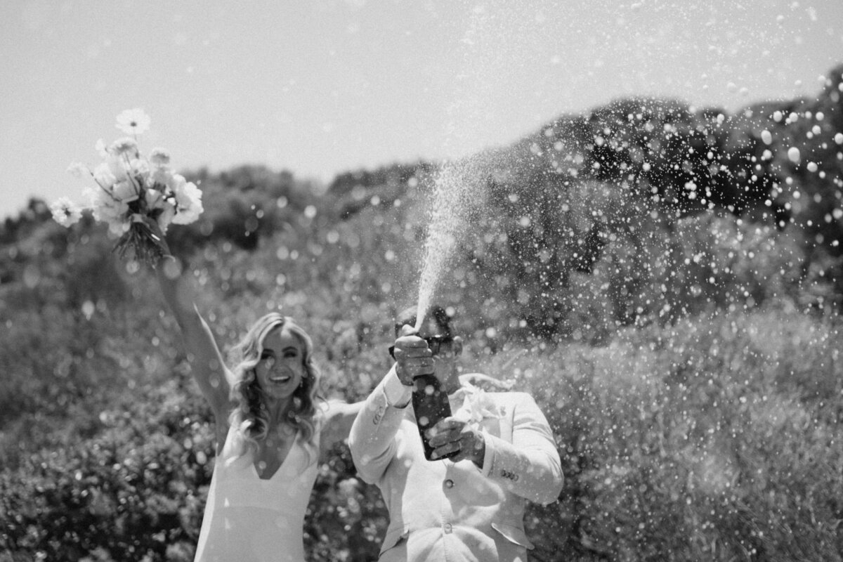 Couple spraying champagne at their wedding