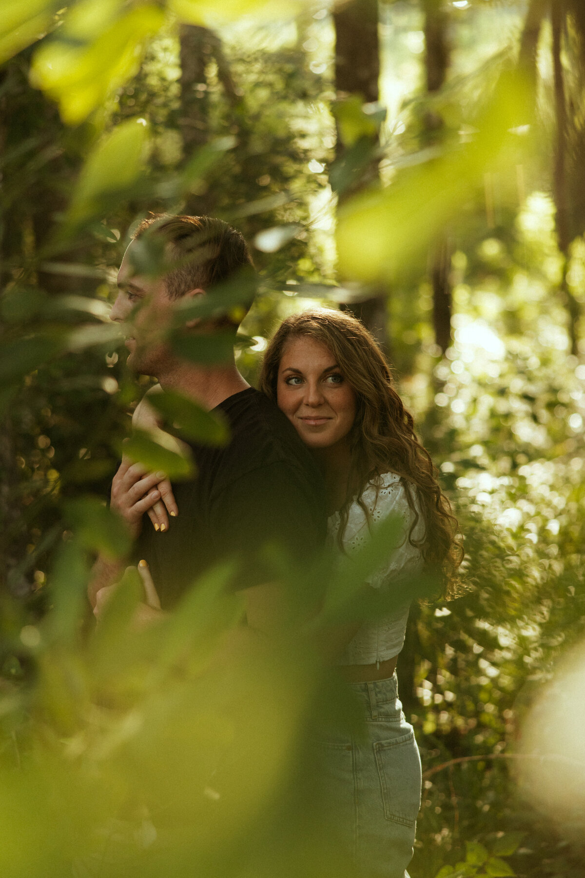Couple posing for portraits in a forest.
