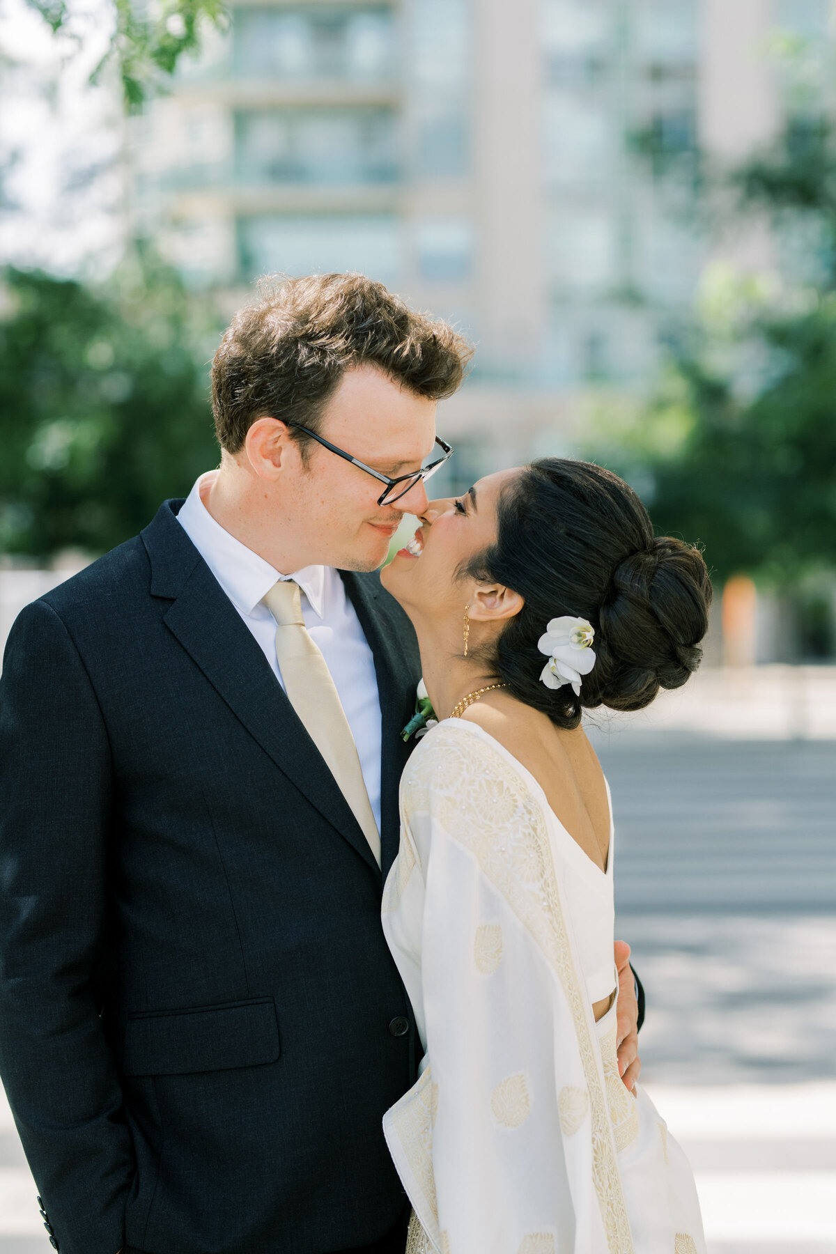 bride and groom sharing a moment together outside in the courtyard at the pearle hotel laughing and kissing