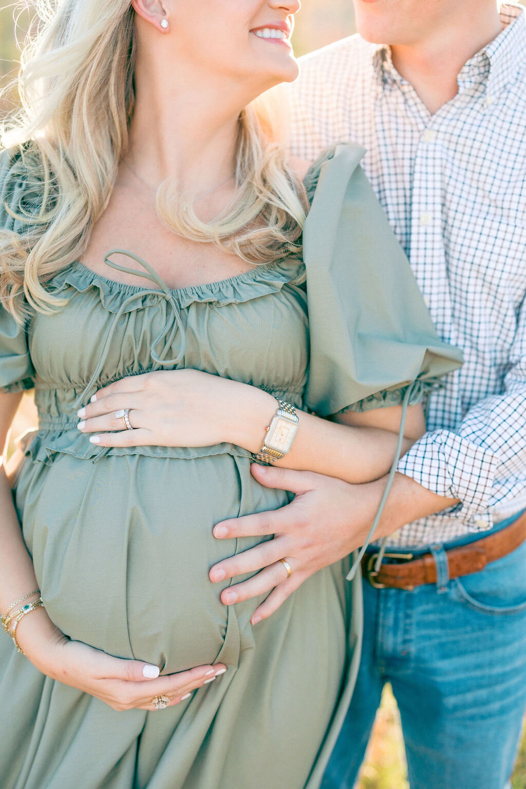 Pregnant woman in green dress holds bump for maternity photos in Georgia