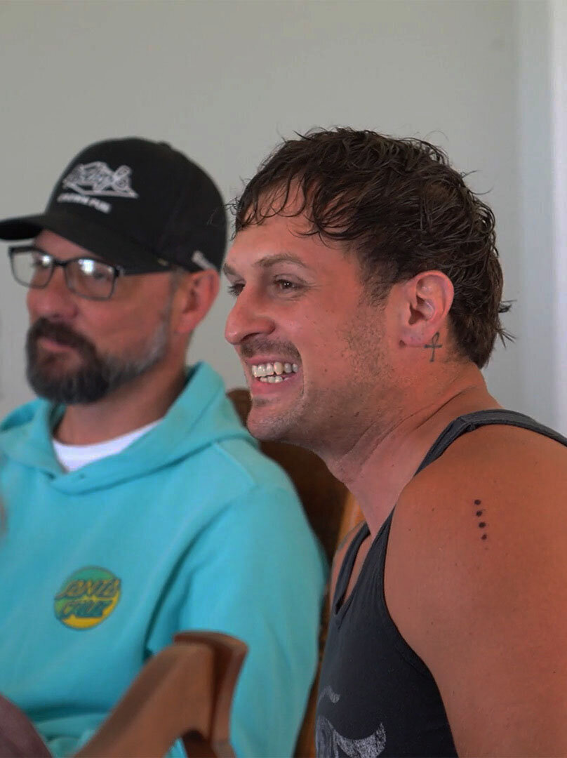 A photo of two men during an integration session at the end of the veteran retreat. One man has visible kambo dots on his arm.