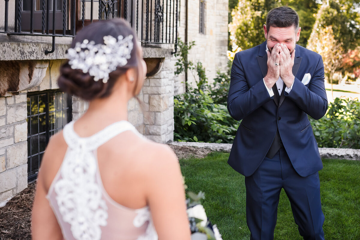 Groom gets emotional seeing his bride during their wedding at Ewing Manor in Bloomington, Illinois