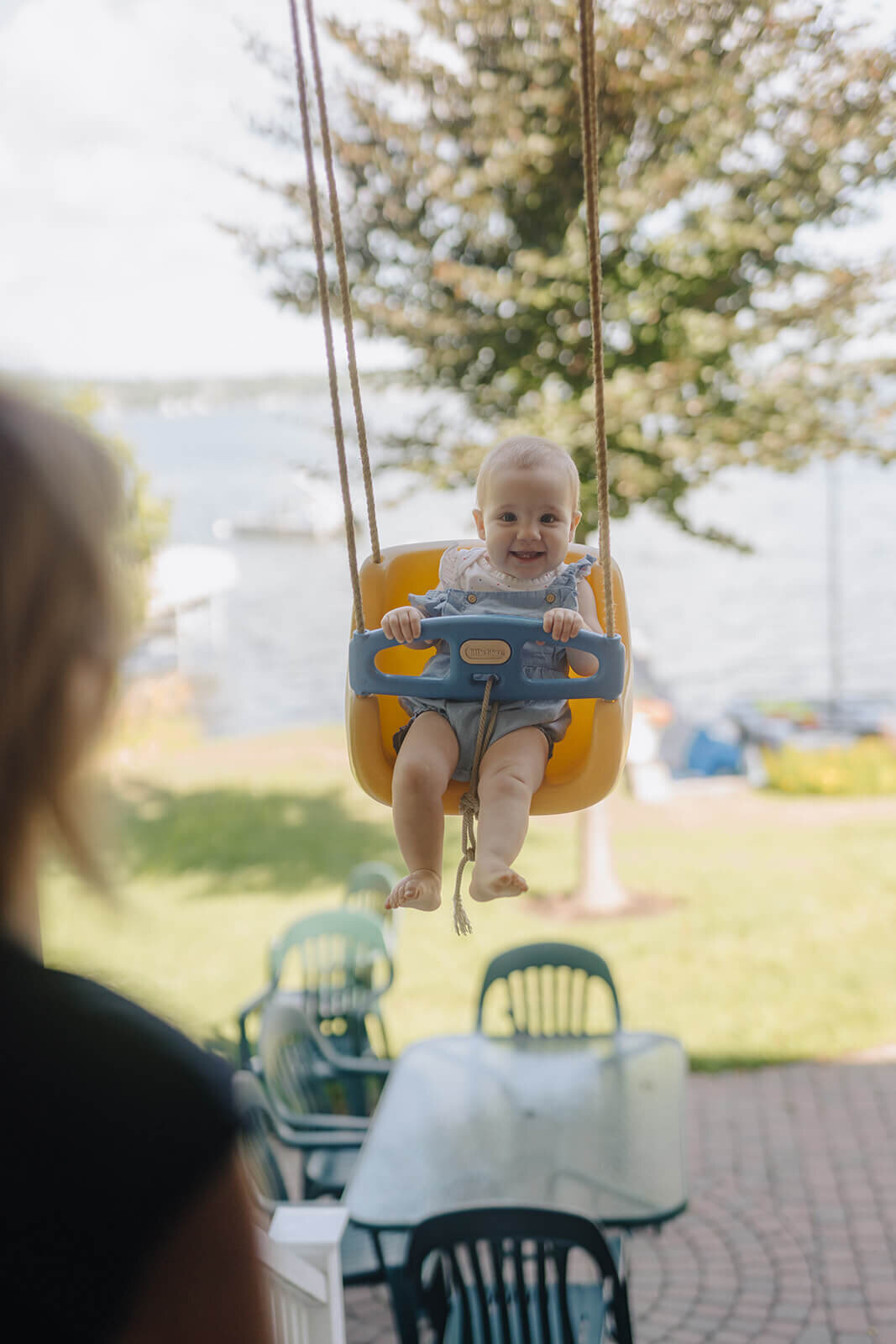 Baby sitting in a swing smiling