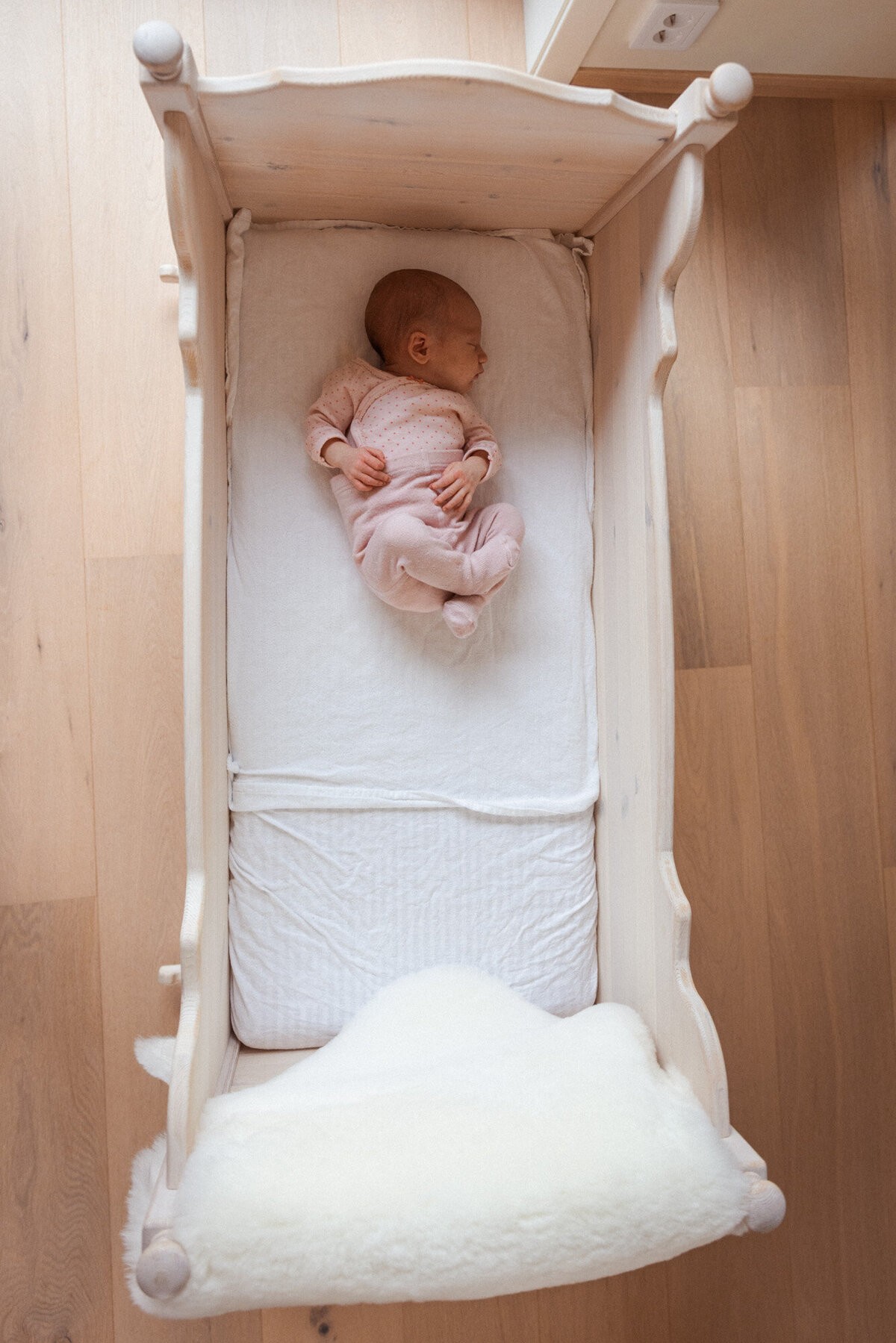 Livsstilsfoto av en baby som sover i en vugge. Fotografert ovenfra og ned.