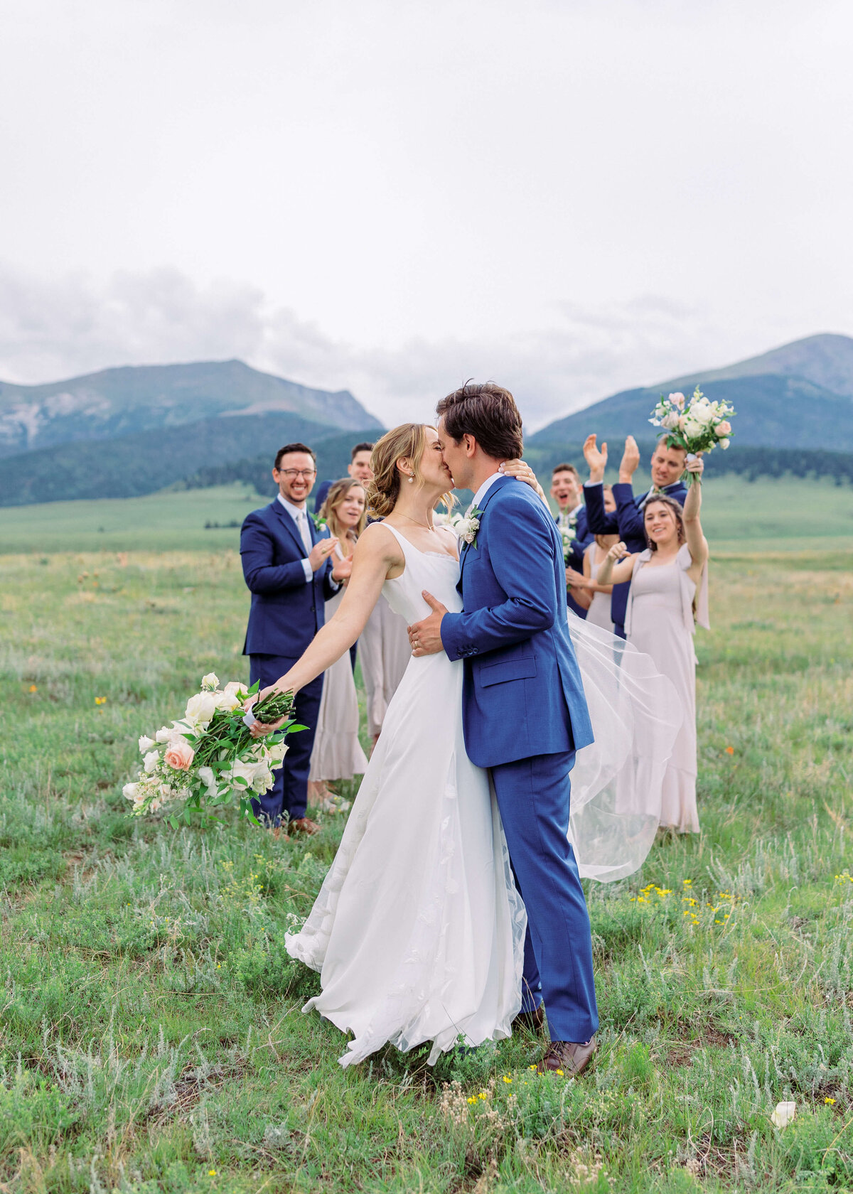Virginia wedding photographer captures a moment of celebration as the bridal party cheers on the couple who are kissing