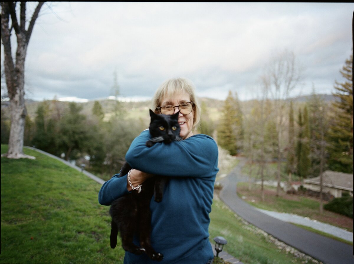 Older woman posing with her cat, captured candidly by Kate Winters Photography in Carmel, California.