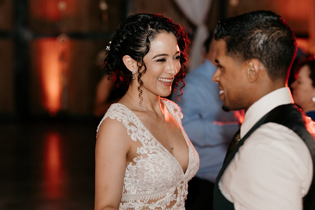 The bride and groom share a close moment on the dance floor, the bride beaming as she gazes at her husband.