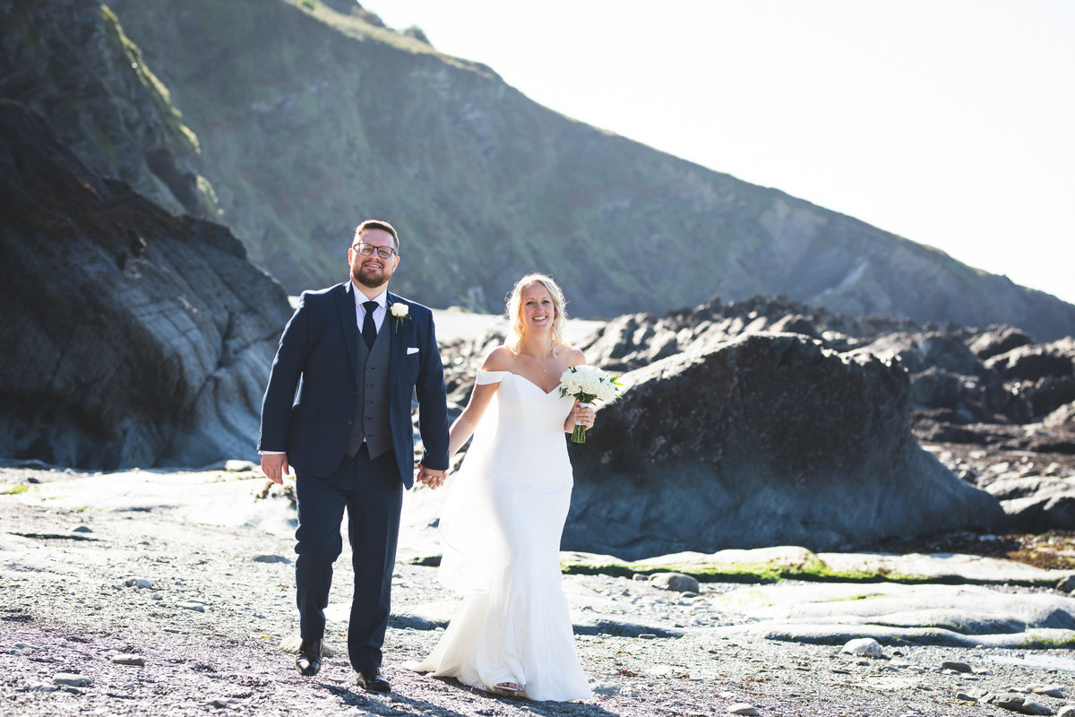 Tunnels Beaches wedding venue in Devon couple walking on the beach