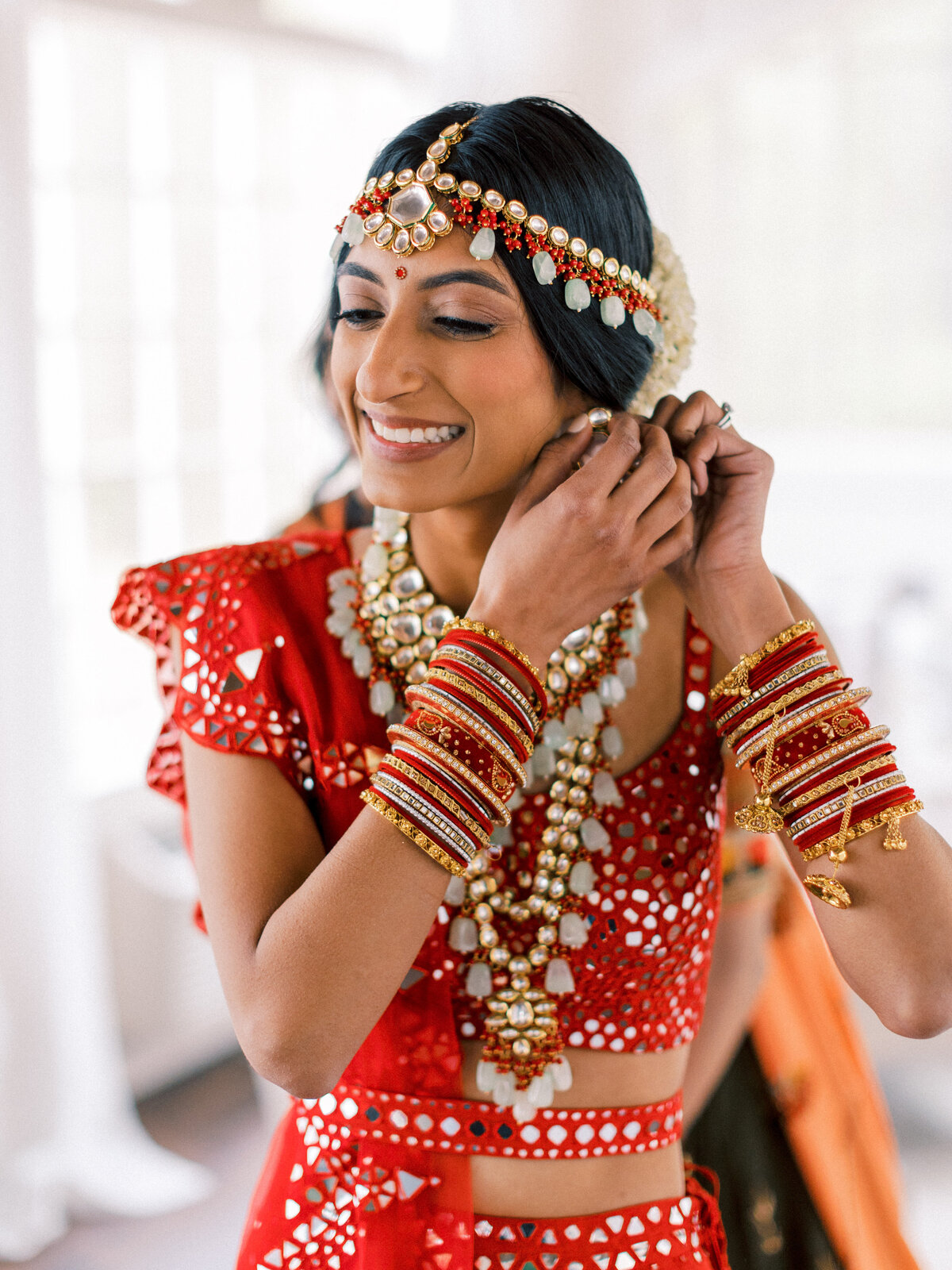 Prianka + Alex - Hindu Wedding 11 - Portraits - Bride chainging out earrings