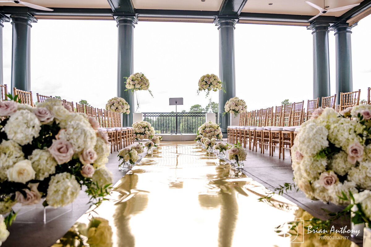 Stunning wedding ceremony setup reflecting golden hues by a waterfront venue.