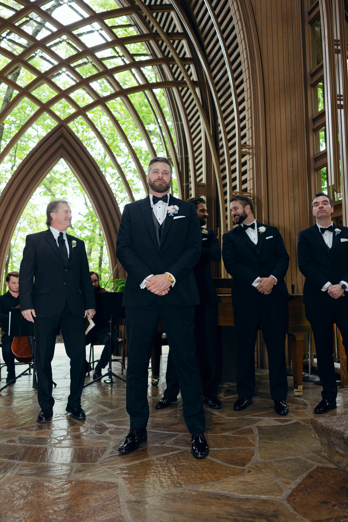 A wedding day photo of the groom watching his bride walk down the aisle at Mildred B Cooper Memorial Chapel in North West Arkansas