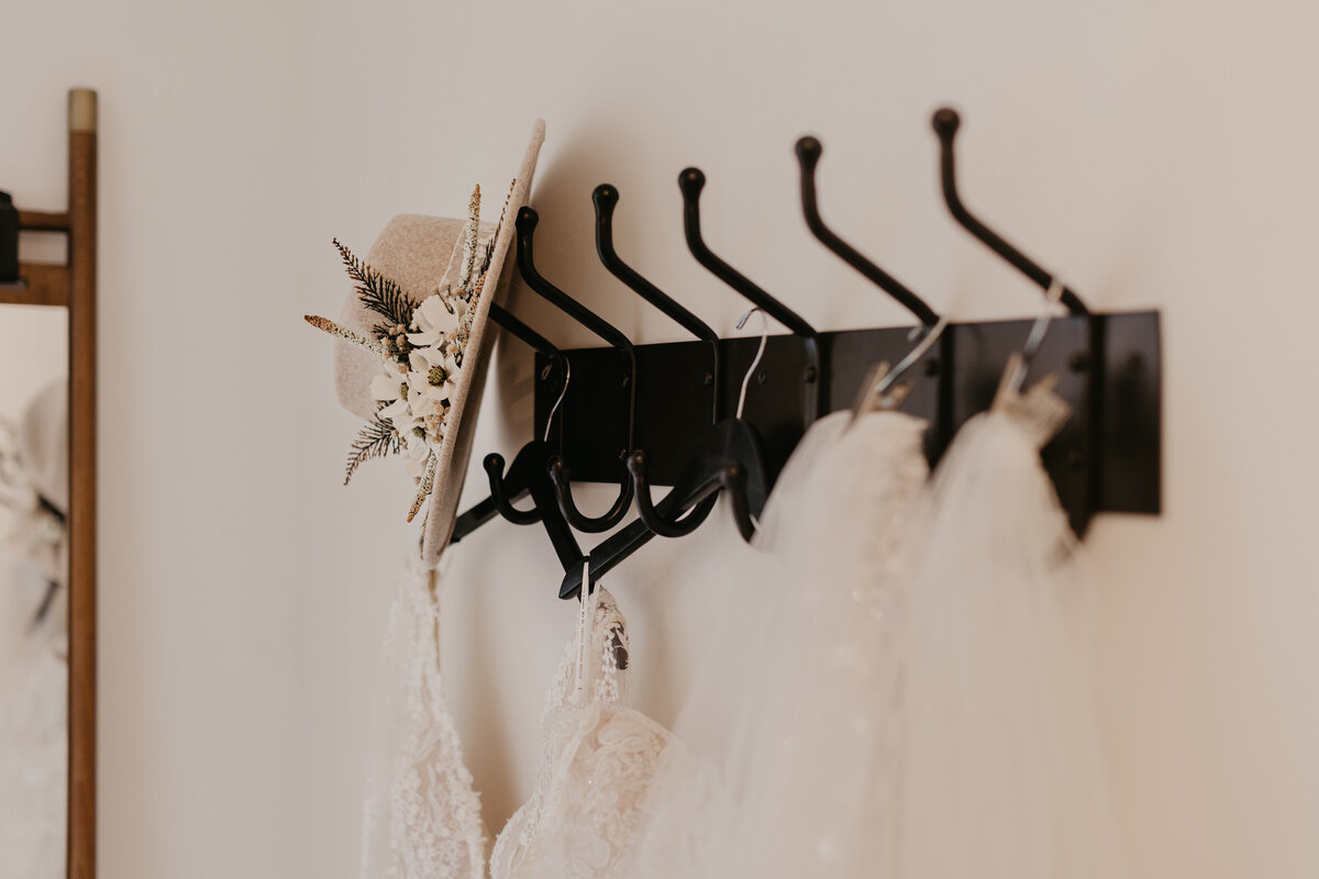 Wedding Dress hanging on Black Rack with Fancy Hat