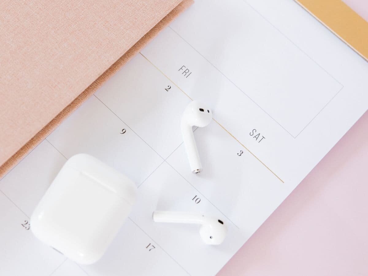 Photo of a notepad calendar and some AirPods