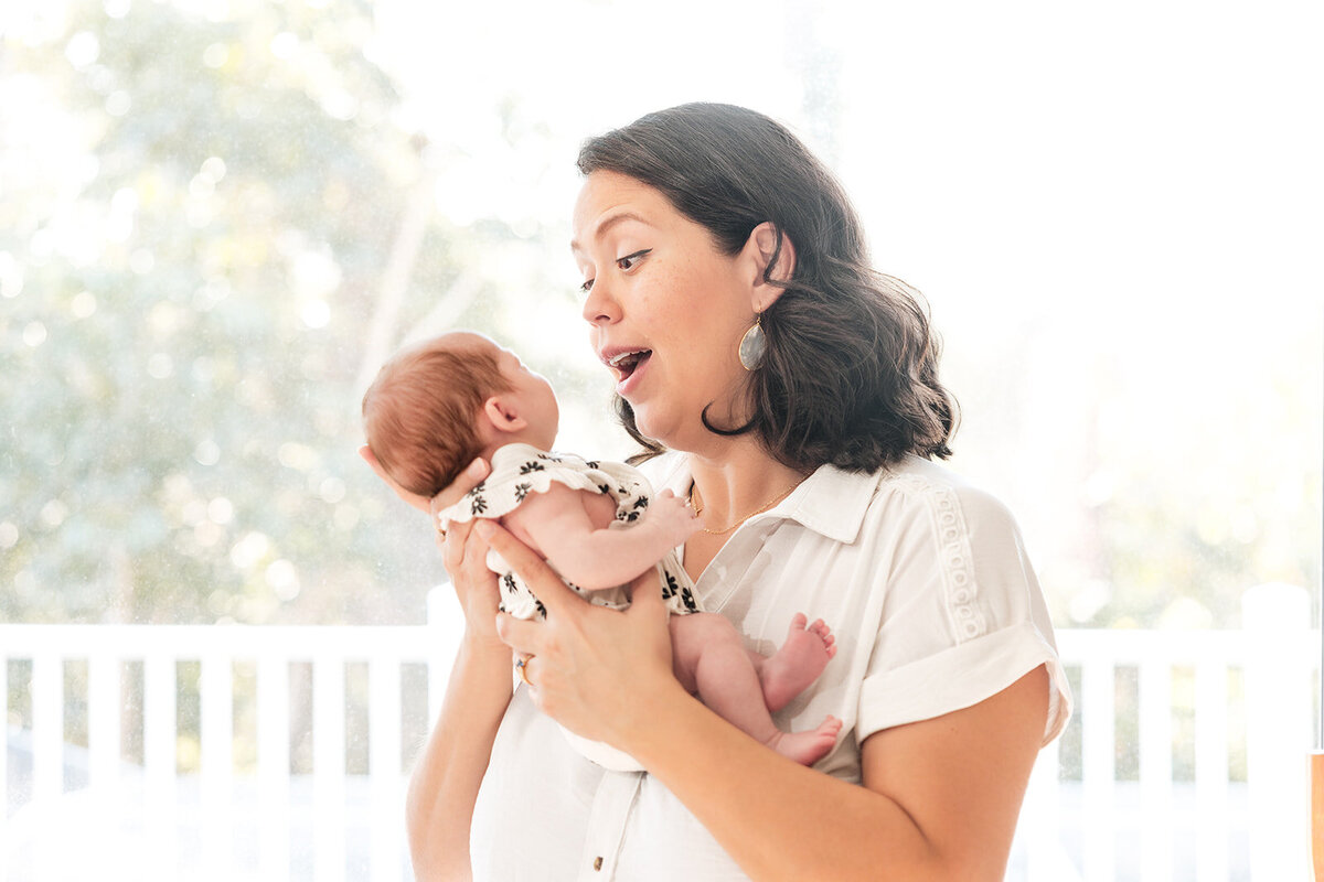 Mother holding newborn during in-home lifestyle photo session in Central Florida


