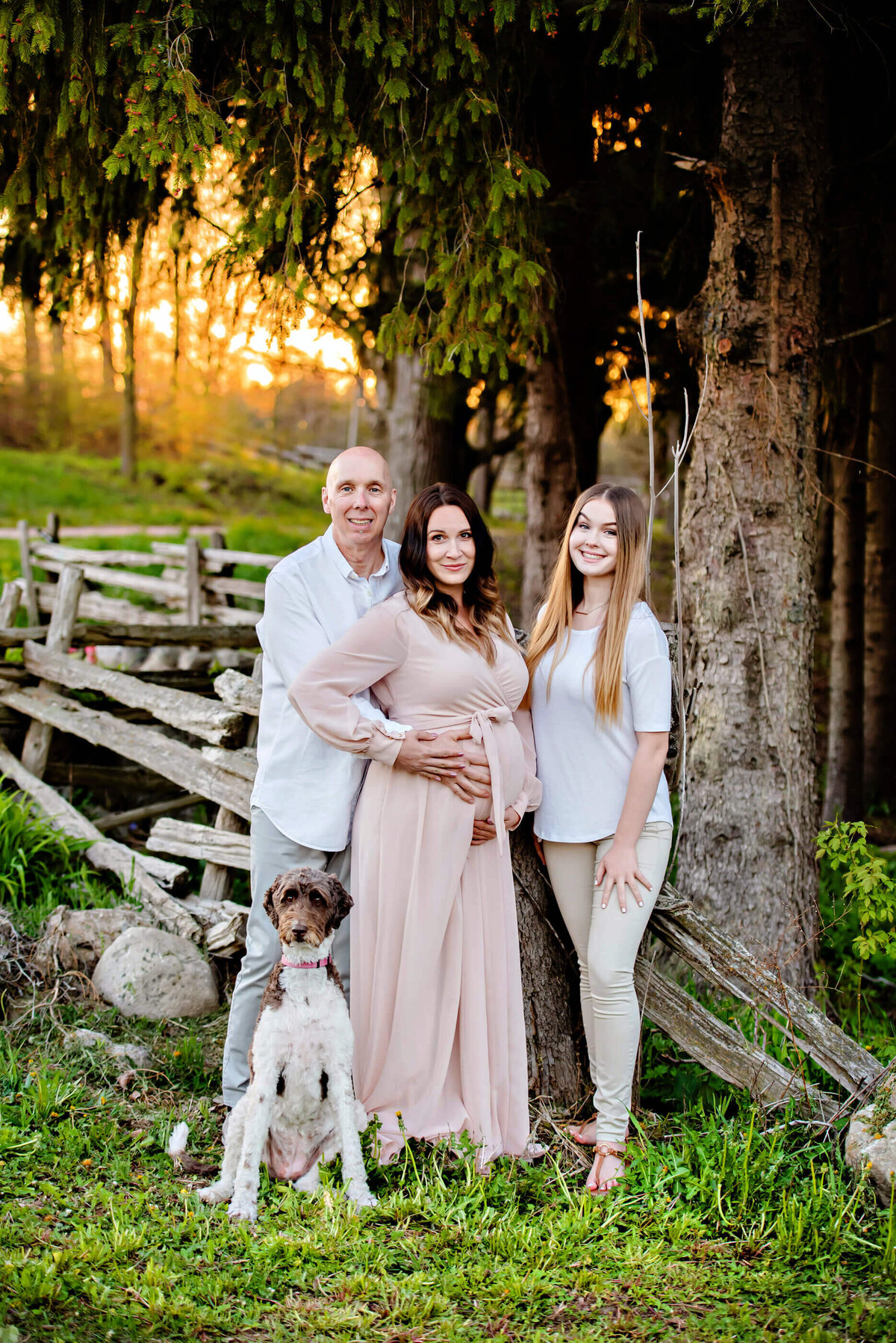 mom and dad with their teenage daughter for their Toronto farm summer maternity photos