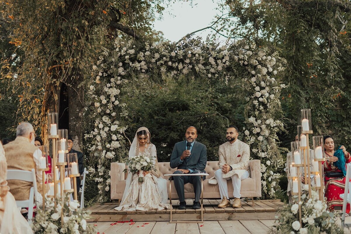 Indian ceremony starting at the Bowery House and Gardens surrounded by white flowers and golden candles.