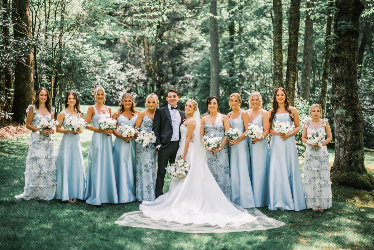 Bride and groom standing with bridesmaids in light blue dresses during an outdoor wedding at Old Edwards Inn in Highlands, North Carolina.