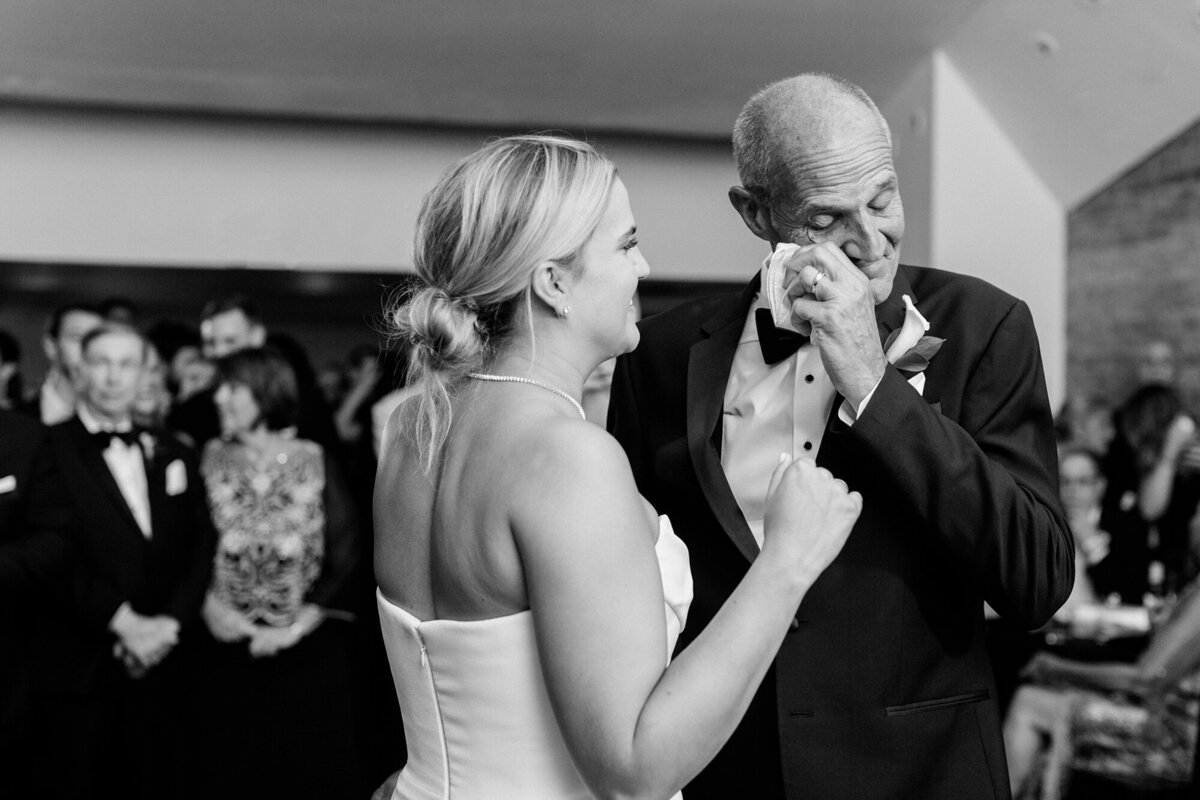 Bride dancing with an emotional father at the wedding reception
