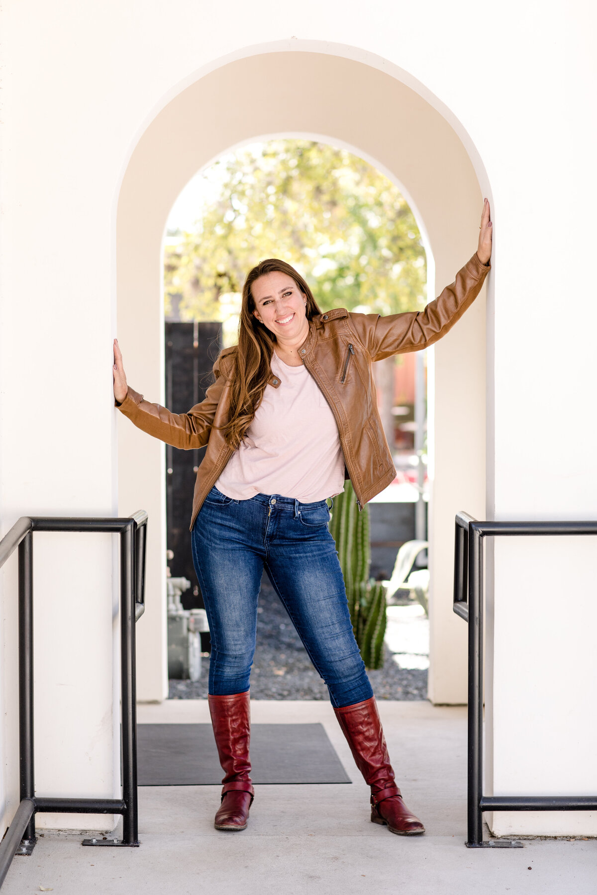 photography branding for denver commercial photographer posing in a doorway while smiling for her headshots