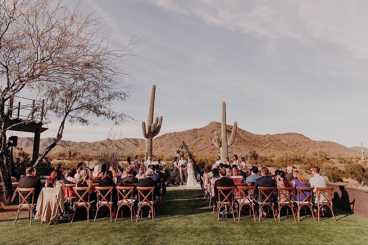 Wedding Ceremony with two brides in the desert with two large saguaros