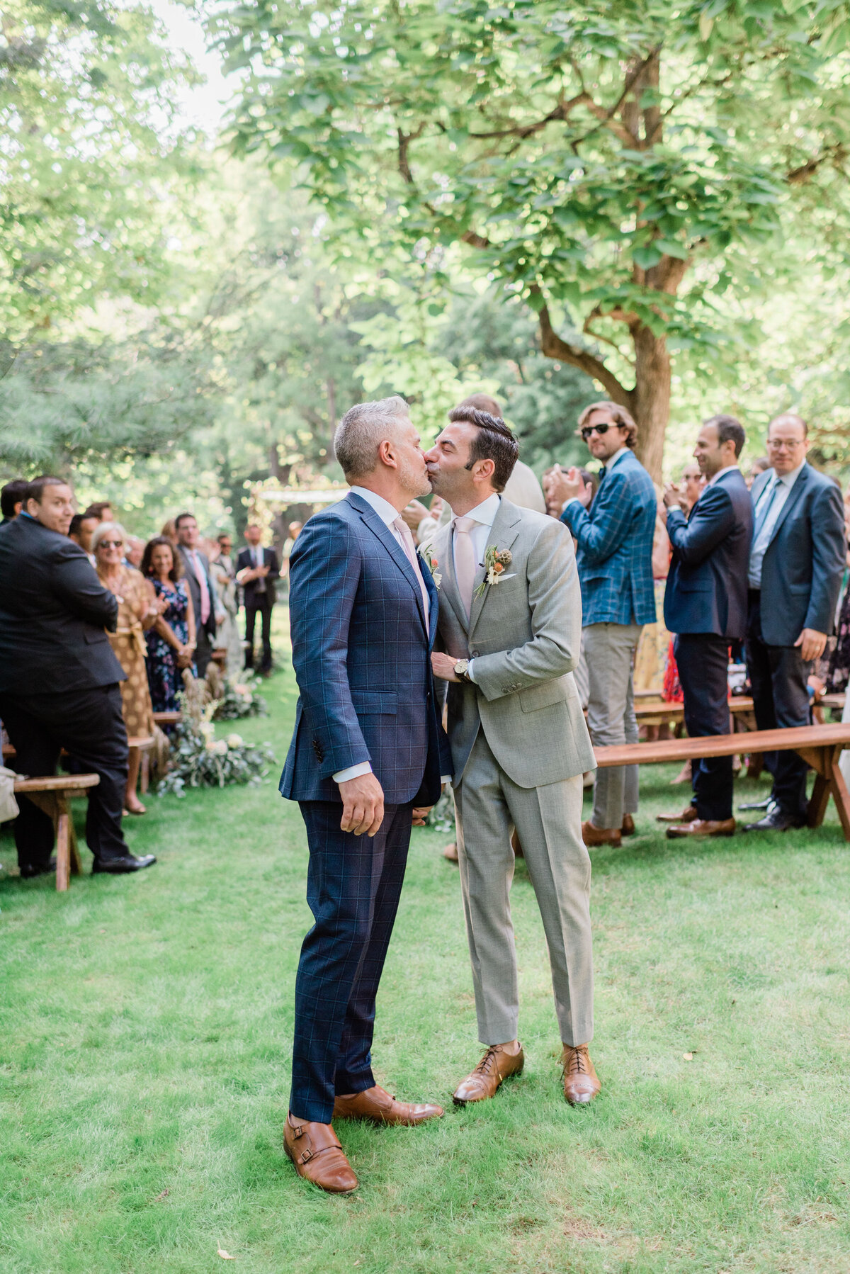 Newlyweds kiss at the end of the aisle 