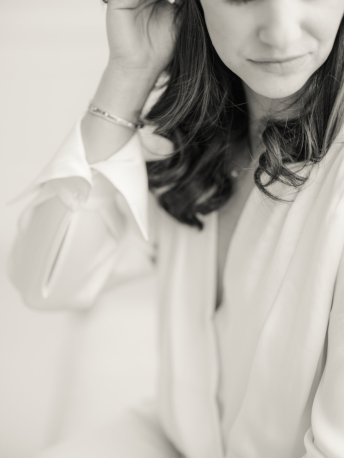 Close up professional branding/headshot photo of a Dallas woman holding her hair behind her ear.