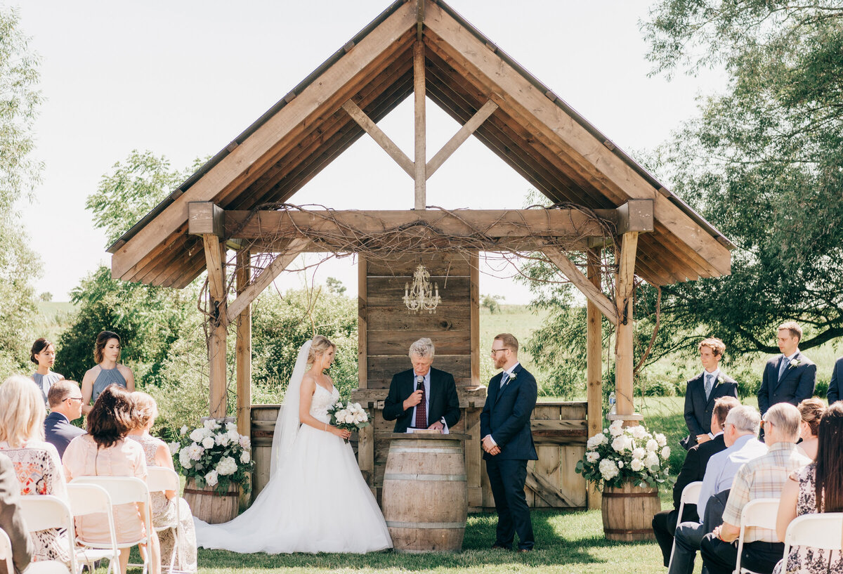 Bride and groom exchanging vows at luxurious outdoor wedding ceremony at Willow Creek Barn photographed by Nova Markina