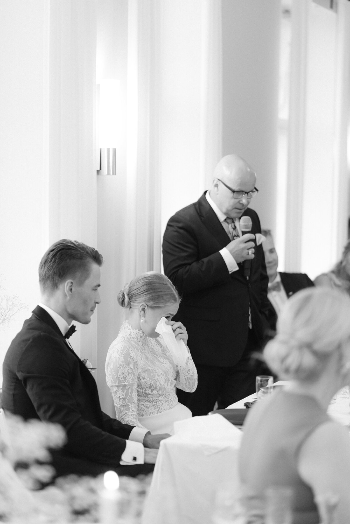 Documentary wedding photograph of a wedding guest giving a speech to bride and groom in Airisniemi manor in Turku, Finland. Atmosphere captured by wedding photographer Hannika Gabrielsson.