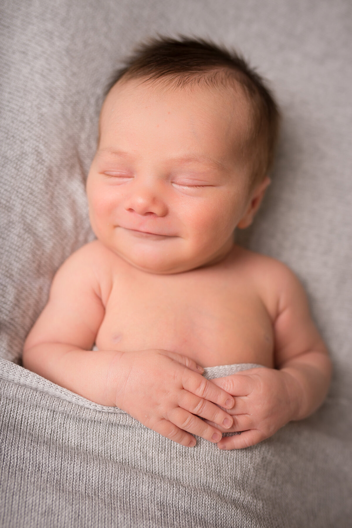 baby smiles, baby fingers, sweet newborn in gray wrap