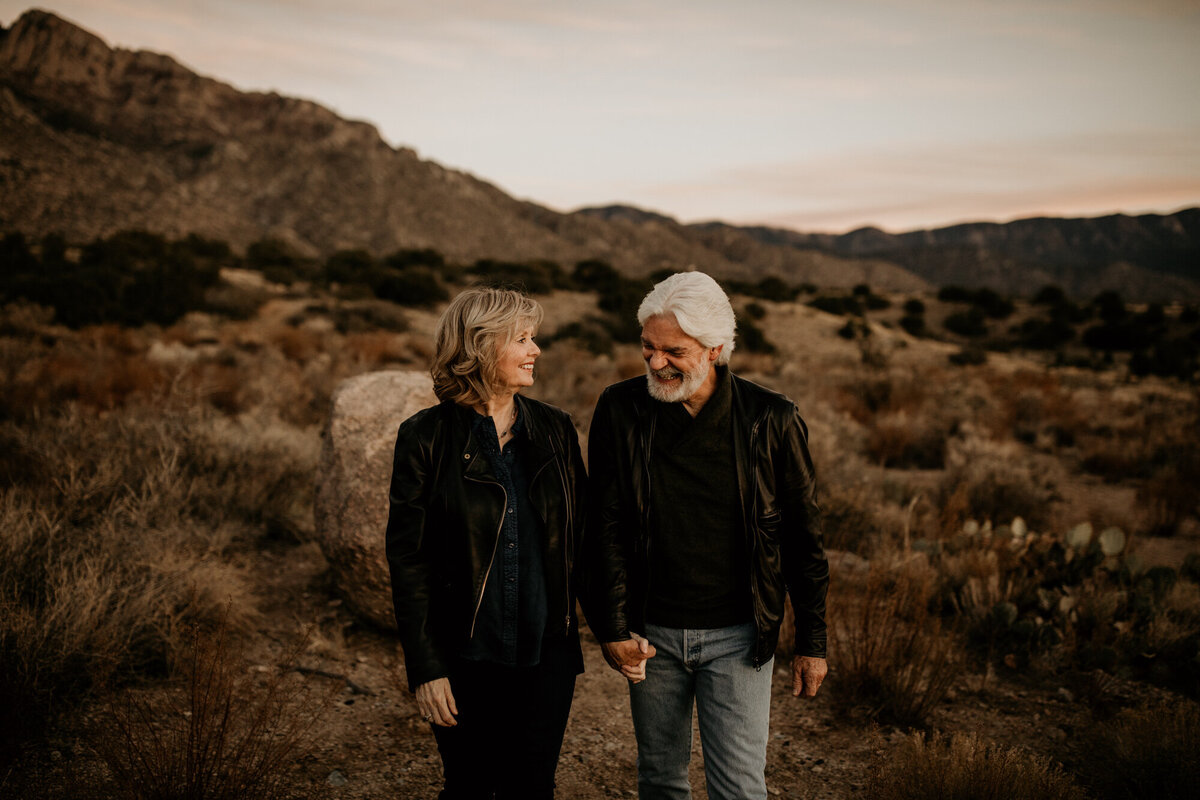Middle aged couple walking and laughing in the desert