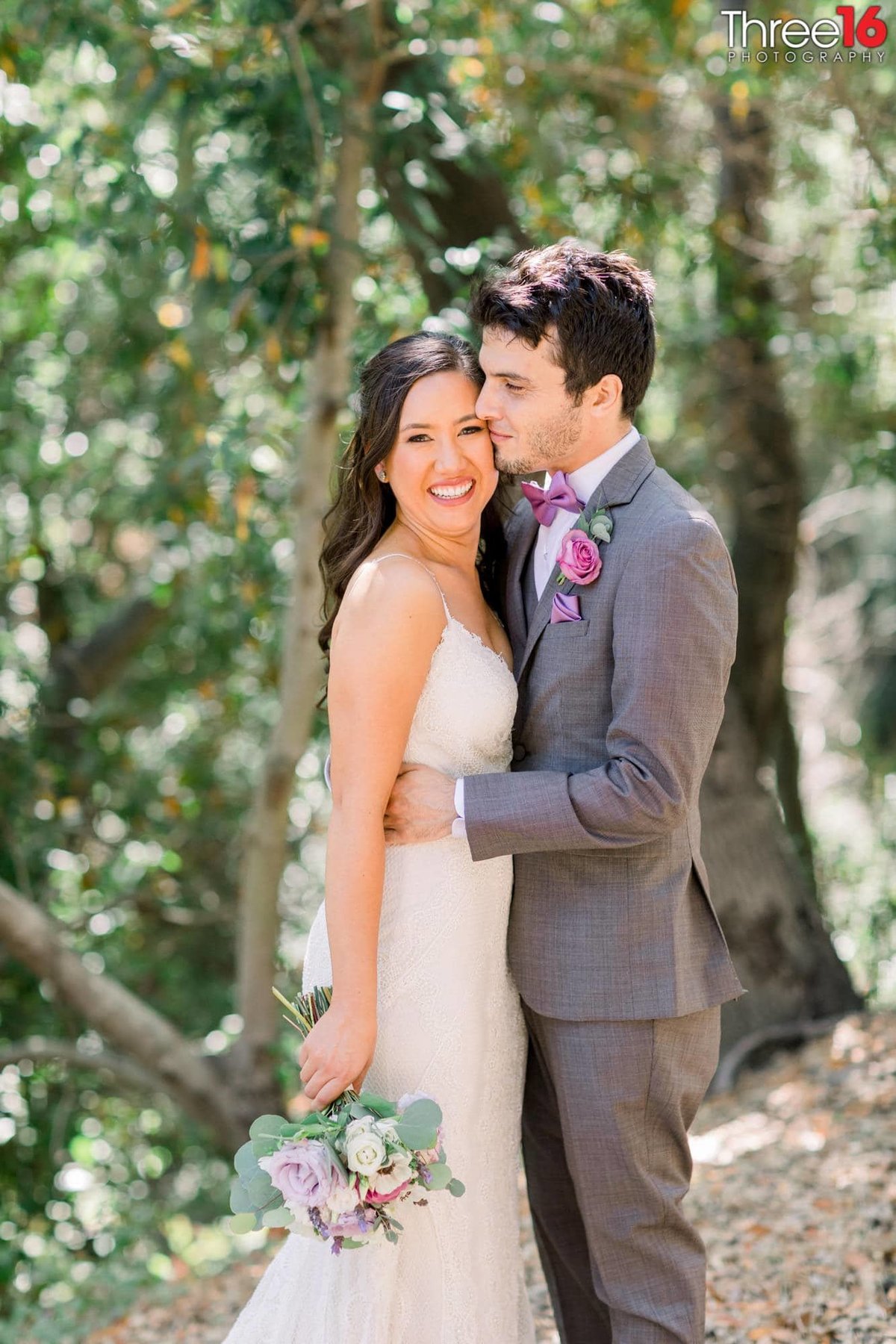 Bride and Groom cozy up to each other as her bouquet is down by her side