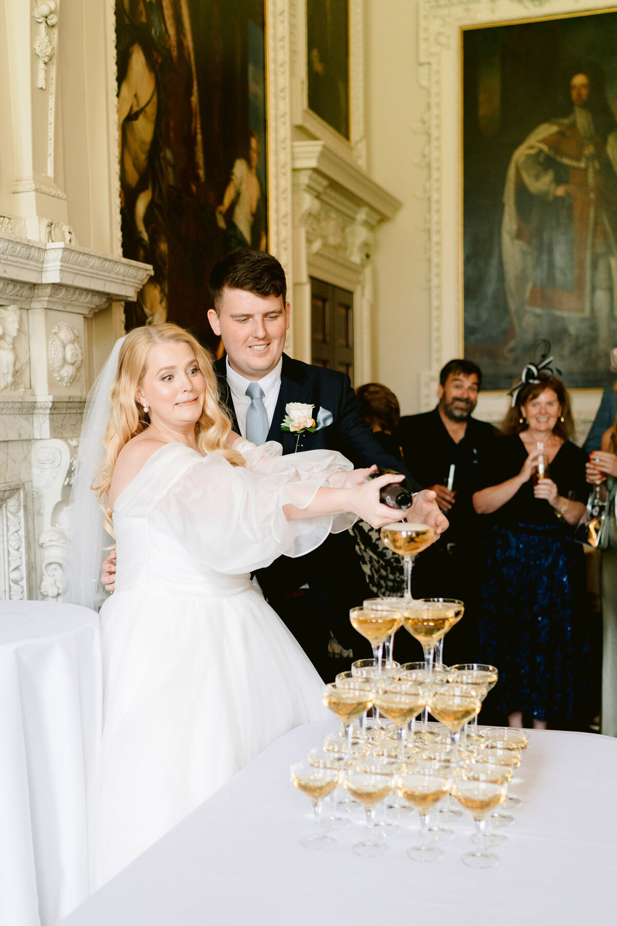 couple pouring champagne tower in the salon at hawkstone hall