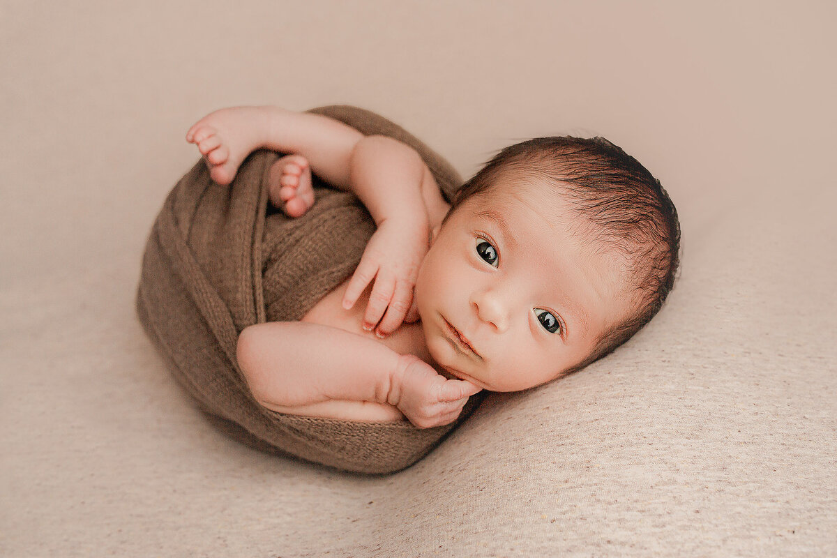 baby stares right at the camera during his newborn photo session in Hamilton