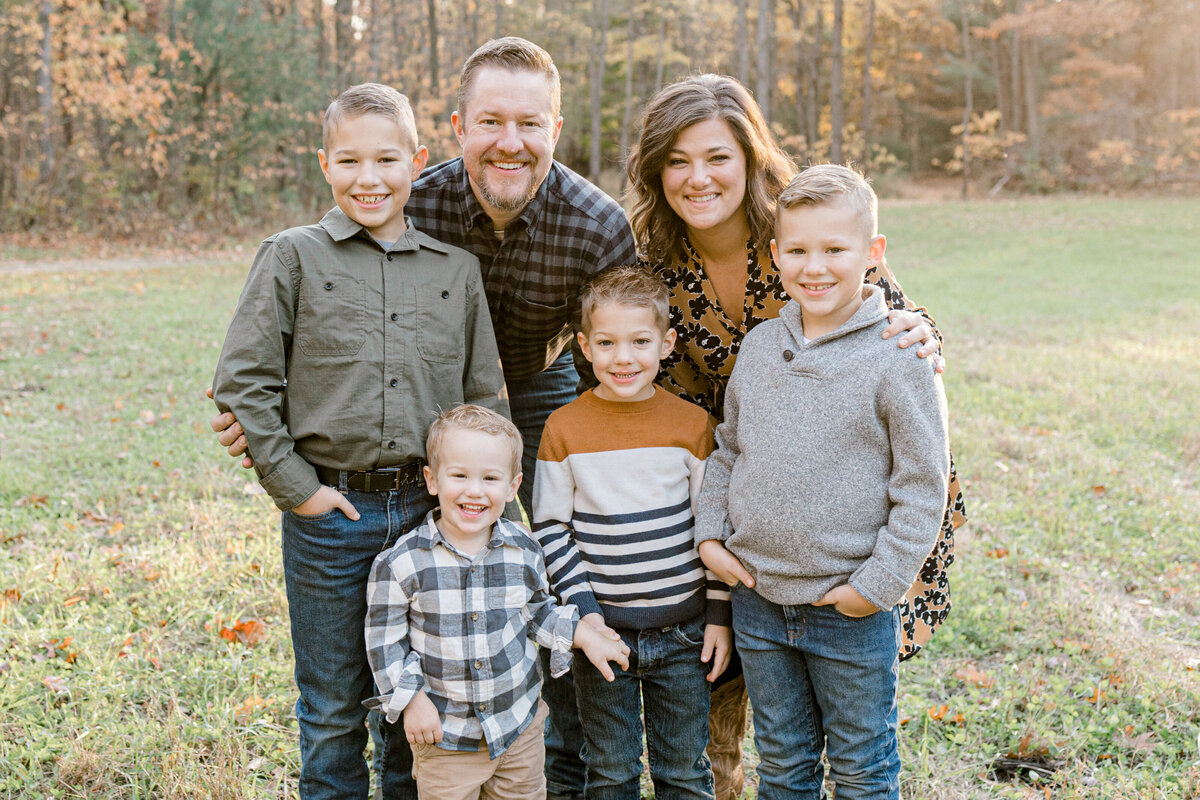 family standing in their yard in a group smiling