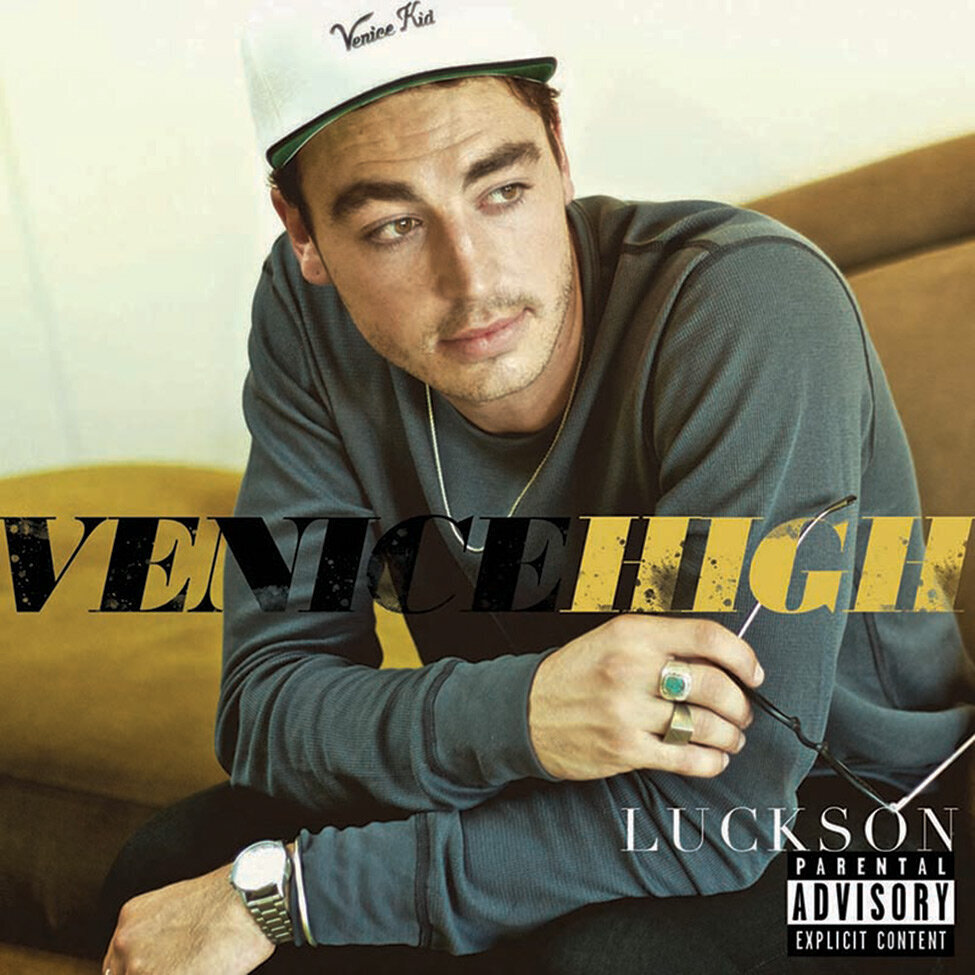 Album Cover Artist Luckson Title Venice High  Singer sitting with arms bent wearing grey long sleeved shirt and white Venice Kid baseball cap