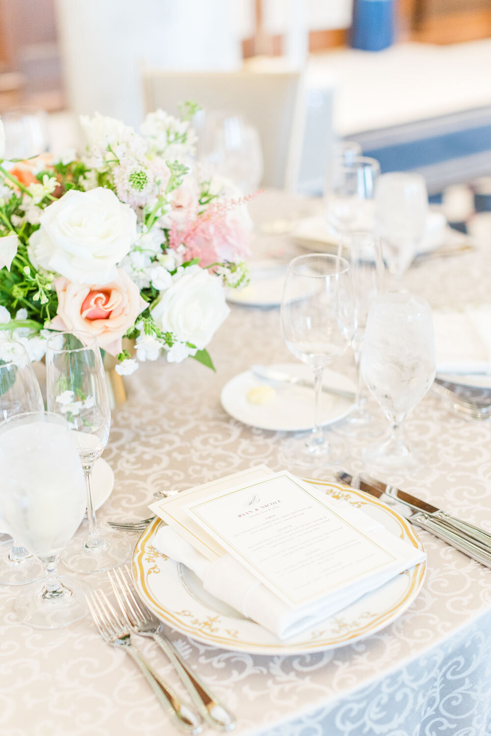 Wedding reception table with floral centerpiece and menu.